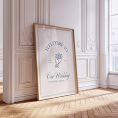 a wedding sign in front of an empty room with white walls and parquet flooring