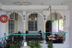 the interior of a house with blue and white decor on the walls, windows, and balcony railings