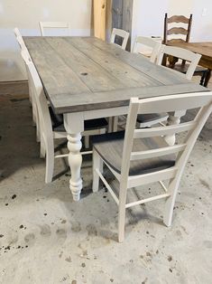 a wooden table with chairs around it in a room that is being renovated and painted white