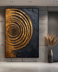 an abstract painting in gold and black on a wall next to a vase with dried grass