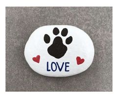 a rock with a paw and hearts painted on it