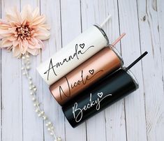 three personalized lip bales are sitting on a table next to a pink flower