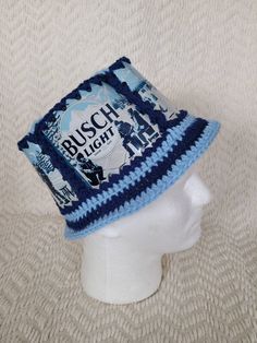 a white mannequin head wearing a blue and white crocheted hat with busch light on it