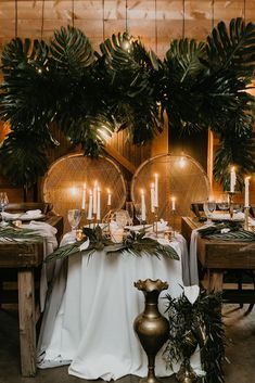 the table is set with candles and greenery