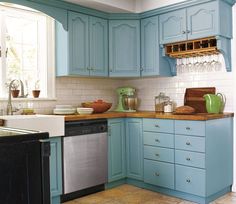 a kitchen with blue cabinets and tile flooring