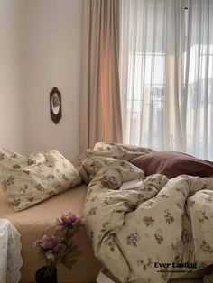 an unmade bed sitting next to a window in a bedroom