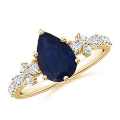 a yellow gold ring with a pear shaped blue sapphire and diamonds