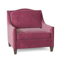 an upholstered pink chair with wooden legs and arm rests on a white background