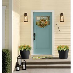 a blue front door with two white planters on the steps