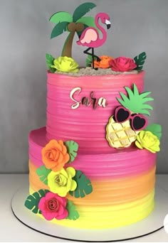 a colorful cake decorated with flowers and a flamingo sitting on top of the cake