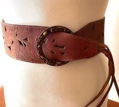 Vintage fashion belts wide brown leather fringed wardrobe accessories cowgirl ITEM DESCRIPTION: Offering this wide brown leather fashion belt. circa estimated 1980s-2000's This adjustable fringed belt features a stencilled leather strap with Tiger's Eye 'stones' (faux?) circling the big round buckle.  The inside belt strap is marked: "L. Leather China".  MEASUREMENTS: This classic hip belt measures approximately 37 1/2 inches full length (including buckle but not including fringe) and 3 inches w Antique Brown Belt Buckle For Festival, Brown Antique Buckle Belt Buckles For Festival, Brown Leather Corset Belt For Festivals, Adjustable Brown Corset Belt With Matching Belt, Vintage Brown Corset Belt With Belt Loops, Bohemian Brown Belt Buckles For Festival, Adjustable Brown Belts For Festival, Adjustable Brown Belt For Festival, Bohemian Brown Belt For Festival