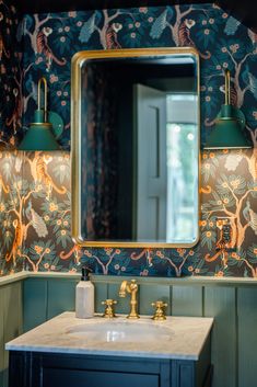 a bathroom sink under a large mirror next to a wall mounted light