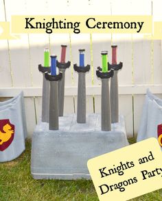 knight's and dragon's party decorations on the grass in front of a fence