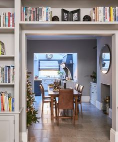 a dining room table surrounded by bookshelves filled with books