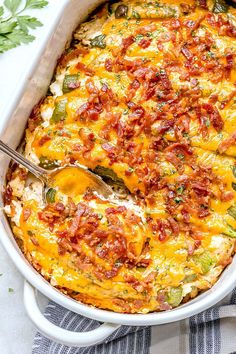 a white casserole dish filled with bacon, cheese and jalapenos