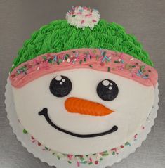 a frosted snowman cake with sprinkles on it