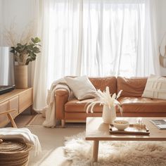 a living room filled with furniture and a window covered in white drapes next to a wooden coffee table