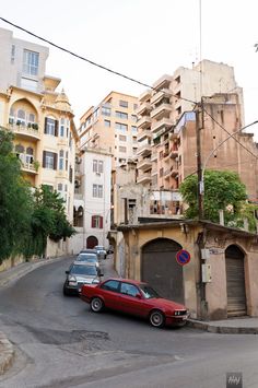 two cars are parked on the street in front of some buildings