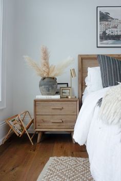 a bedroom with a bed, nightstand and pictures on the wall