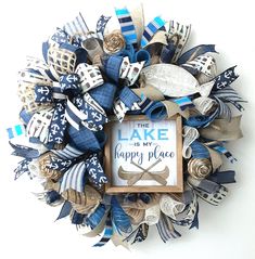 a wreath made out of blue and white ribbons with a sign that says the lake is my happy place