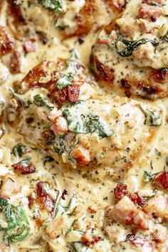 a close up view of some meat covered in cheese and spinach on a plate