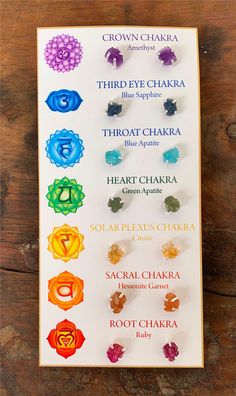 the seven chakras are arranged on top of a white board with wooden background