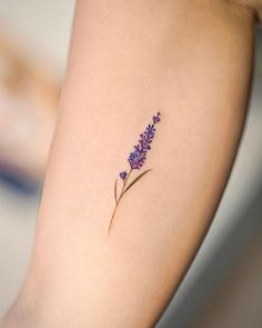 a close up of a person's arm with a flower tattoo on the side