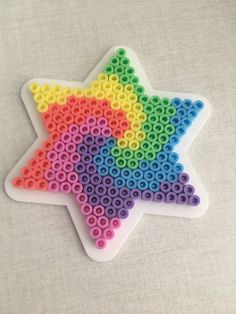 an ornament made out of plastic beads with a star shape in the middle