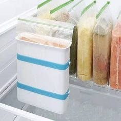 an open refrigerator filled with lots of different types of food in plastic bags on the shelves