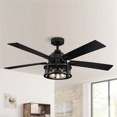 a black ceiling fan with three lights in a living room next to a brick wall