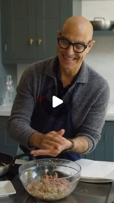 a man wearing glasses and an apron is making food in a bowl on the kitchen counter