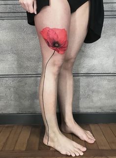 a woman's legs with a red flower tattoo on her left thigh and the lower leg