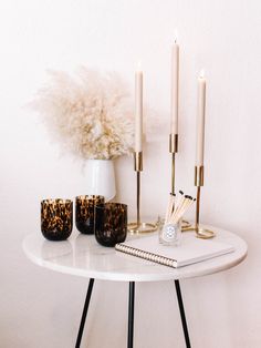 a white table topped with candles and vases