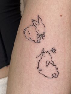 a small rabbit tattoo on the right side of the calf's leg, with another bunny behind it