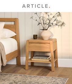 a bedroom with a bed, nightstand and vase on the side table next to it