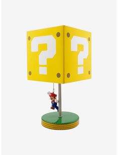 a lamp that has a mario mouse hanging from it's base with a question mark on it