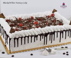 a white cake with chocolate and cherries on top