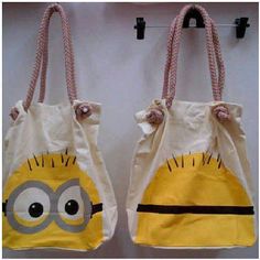 two yellow and white bags with eyes on them hanging from hooks in front of a wall