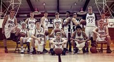 a group of young men sitting on top of a basketball court next to each other