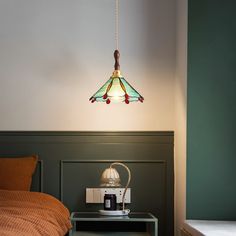 a lamp hanging over a bed next to a night stand