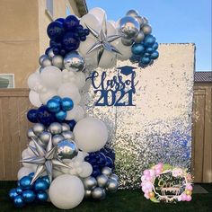 a balloon arch is decorated with blue and silver balloons