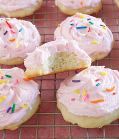 frosted cupcakes on a cooling rack with pink icing and sprinkles