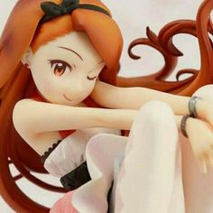 a close up of a figurine sitting on a chair with her arms crossed