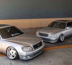 two silver cars parked next to each other in a parking lot