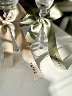 two wine glasses with ribbons tied around them