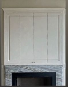 a fireplace with white cabinets above it