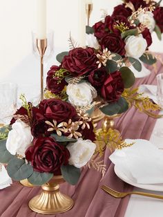 the centerpieces are arranged in gold vases with red and white flowers on them