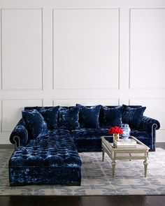 a living room with blue velvet furniture and white walls