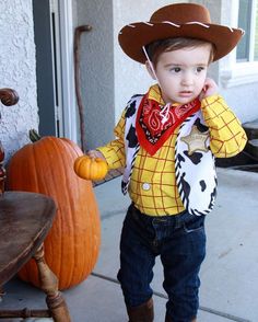 a young boy wearing a cowboy hat and bandana