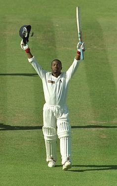 a cricket player holding his bat in the air